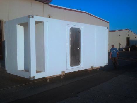 Finished composite modular unit exterior with worker for scale